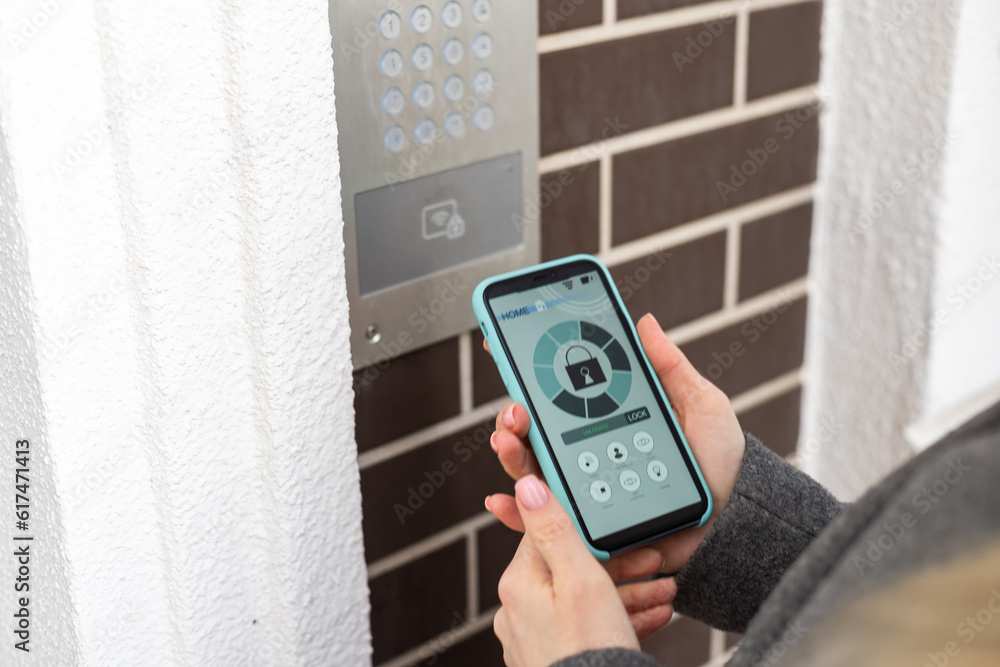 Poster woman locking smartlock on the entrance door using a smart phone. concept of using smart electronic 