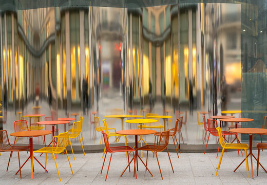 Oronge und Gelbe Gartenmöbel spiegeln sich an einer Glaswand, paris
