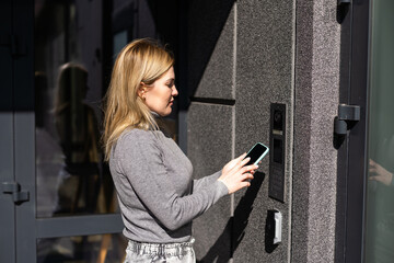 female entering secret key code for getting access and passing building using application on mobile phone, woman pressing buttons on control panel for disarming smart home system