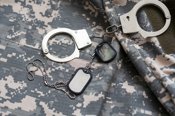 Handcuffs on a Camouflage background. Metal shackles isolated. Law. Limitation. Freedom. Security....