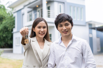 Obraz premium New home owner happy family asian young couple love, wife hug husband, showing house key. Banker agreement mortgage loan purchase buy, property lease real estate for relocation after married.