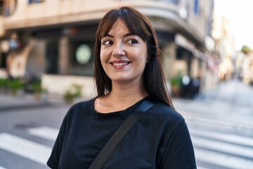 Young beautiful hispanic woman smiling confident looking to the side at street