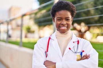 African american woman wearing doctor uniform standing with arms crossed gesture at street