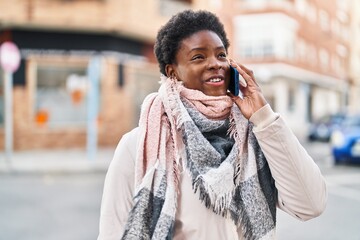 African american woman smiling confident talking on the smartphone at street