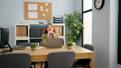 Young redhead woman business worker using laptop working at office