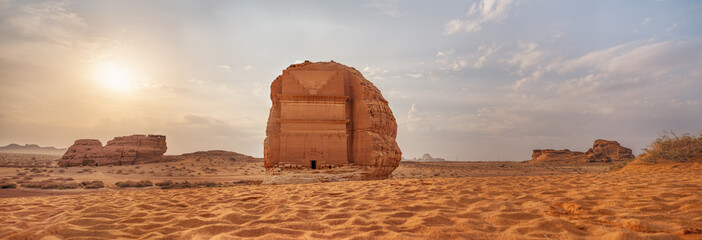 Tomb Lihyan Son of Kuza or Qasr al-Farid at Hegra, Saudia Arabia - most popular landmark in Mada'in Salih archaeological site, sandy desert landscape, morning sun background - high resolution panorama