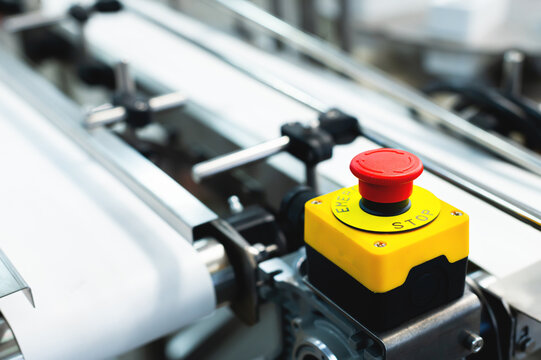 Emergency stop button of the production line on the background of the conveyor belt of the production line without product