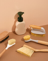 Beige dispenser with cleaning agent and many brushes of different shapes and sizes for cleaning. Household cleaning.