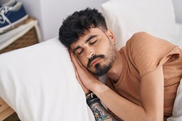 Obraz premium Young hispanic man lying on bed sleeping at bedroom