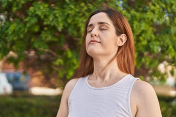 Naklejka premium Young woman smiling confident breathing at park