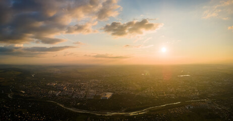 Aerial view from high altitude of distant city covered with puffy cumulus clouds forming before...