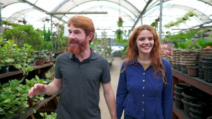 Enthusiastic Redhead Couple Engaged in Plant Shopping at Local Flower Store
