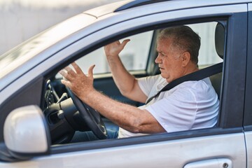 Fototapeta na wymiar Middle age grey-haired man stressed driving car at street
