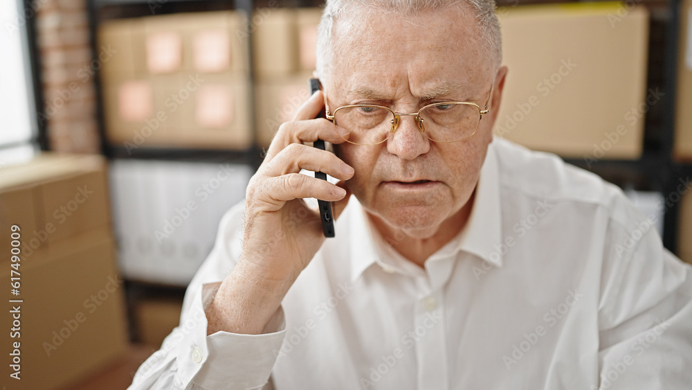 Poster Middle age grey-haired man ecommerce business worker talking on smartphone at office