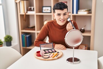 Young non binary man smiling confident applying makeup at home