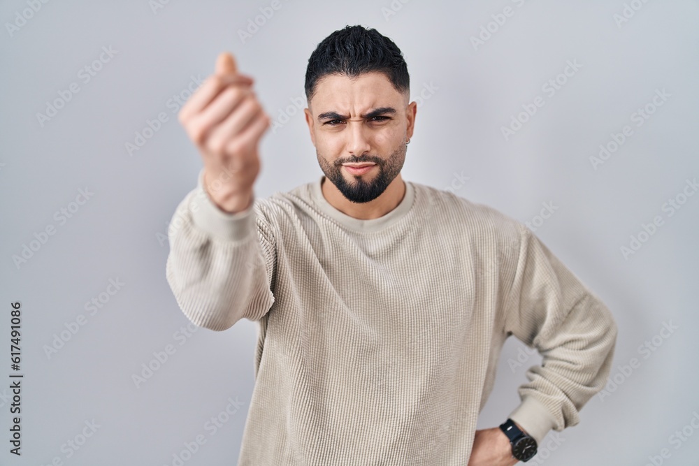 Poster Young handsome man standing over isolated background doing italian gesture with hand and fingers confident expression