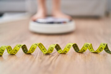 Young caucasian woman weighing at home