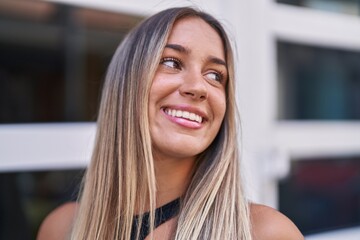 Young beautiful hispanic woman smiling confident looking to the side at street