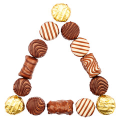 Triangle made of chocolate candies isolated on white background