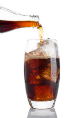 Pouring cola soda drink into the glass with ice on white background