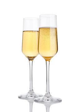 Glasses of champagne with bubbles on white background