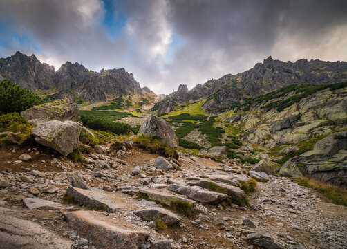 Rocky Hiking Trail with Sun Shining From Behind the Peaks in Mountains Under Dramatic Sky. Mlynicka Valley, High Tatra, Slovakia.