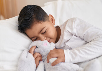 Adorable hispanic boy lying on bed sleeping at bedroom