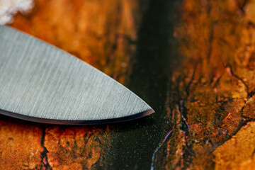Cutting edge of kitchen knive closeup. Tip of knive on background of wooden surface - 617502460