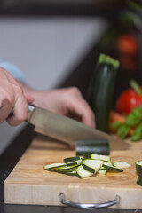 Chef preparing vegetables for vegetarian dish, on wooden cutting board.