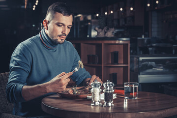 young handsome man eating at the restaurant