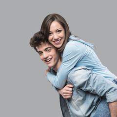 Smiling young couple having fun together and piggybacking