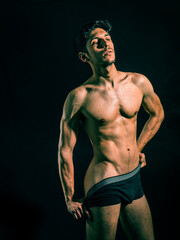 Fototapeta na wymiar Muscular man pulling down underwear to show his butt