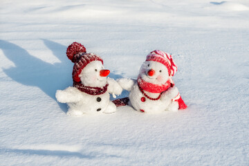 Couple of snowmen taking hand of each other