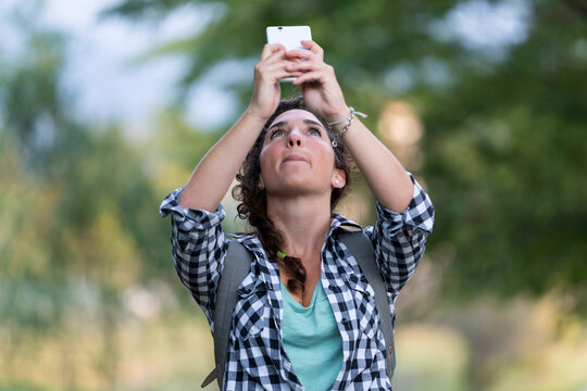 woman taking pictures with her smartphone in the middle of the nature