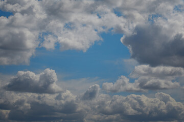 White cumulus clouds formed a gap in which the blue sky can be seen