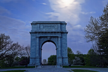 Fototapeta na wymiar Springtime predawn moonlight at Valley Forge National Historical Park in Pennsylvania, USA.The National Memorial Arch is a monument dedicated to George Washington and the United States Continental Arm