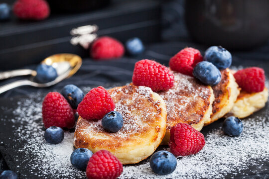 Cottage cheese pancakes decorated with fresh raspberries and blueberries