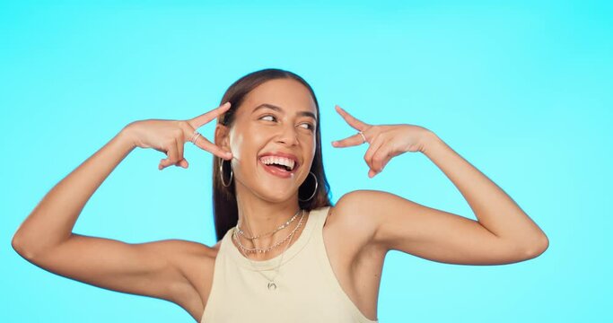 Peace sign, smile and happy with face of woman in studio for support, playful and motivation. Emoji, v sign and excited with portrait of person on blue background for freedom, review and confidence