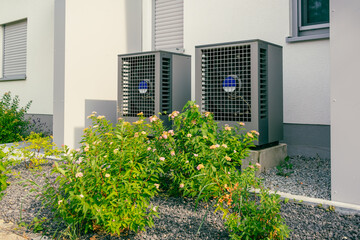 Modern air source heat pumps installed outside of new and modern city house