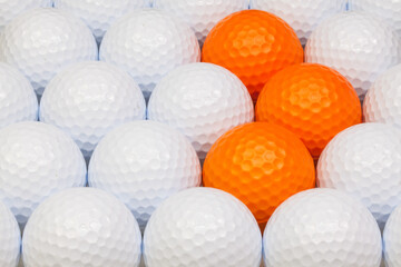 White and orange golf balls in the open box