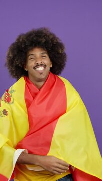 Smiling african man wrapping with a spanish flag