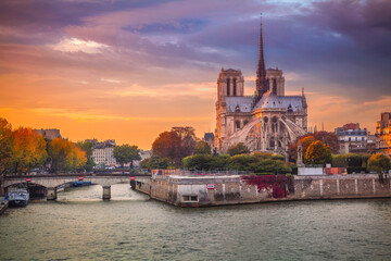 Cityscape image of Paris, France with the Notre Dame Cathedral during sunset.