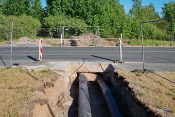 Construction of a new heating main under the road..Installing the pipe by drilling under the...
