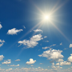 Fototapeta na wymiar Bright sun on beautiful blue sky with white clouds.