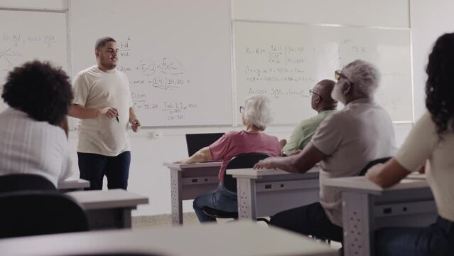 Brazilian senior student in an adult class raising his hand to clear a doubt during math class at a school in Brazil
