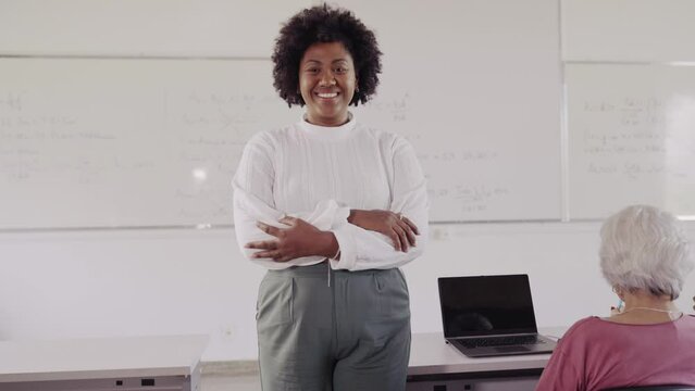 smiling with his arms crossed in the classroom on an adult course in Brazil