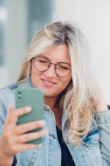 Urban portrait young woman plus size wearing denim texting on mobile phone.