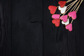 Gingerbreads for Valentines Day or wedding theme on black wooden background