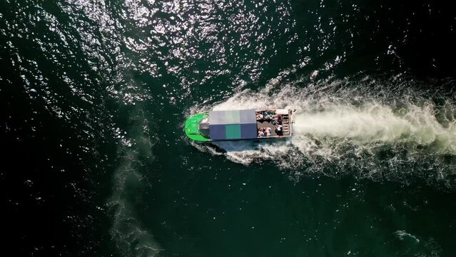 Top View of an Amphibious Tour Bus Floating in the Ocean off the Coast of Halifax Canada. Aerial View. Drone Shot Following an Amphibious Boat with Tourists Floating and Receding at the Waterfront. 