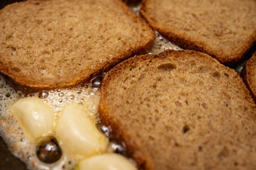 An appetizer for beer and a great addition to first courses. Natural toasts from rye bread. White crackers. Butter croutons, short black Borodino croutons. The process of cooking in a pan
